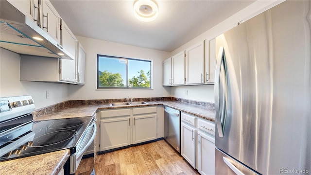 3526 S Depew St Unit 102, Lakewood, CO 80235 - kitchen with appliances with stainless steel finishes, under cabinet range hood, light wood finished floors, and white cabinets