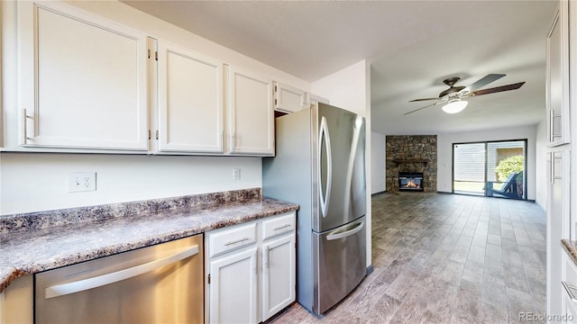 3526 S Depew St Unit 102, Lakewood, CO 80235 - kitchen with appliances with stainless steel finishes, white cabinets, ceiling fan, and light wood-type flooring