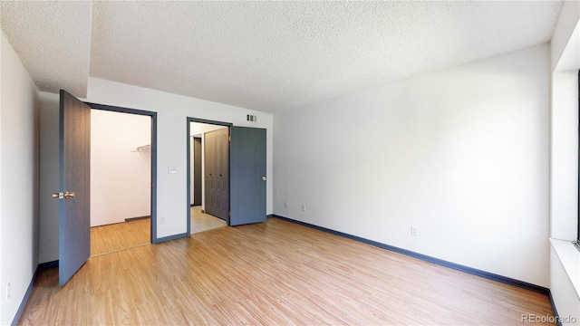 3526 S Depew St Unit 102, Lakewood, CO 80235 - unfurnished bedroom featuring light wood finished floors and a textured ceiling