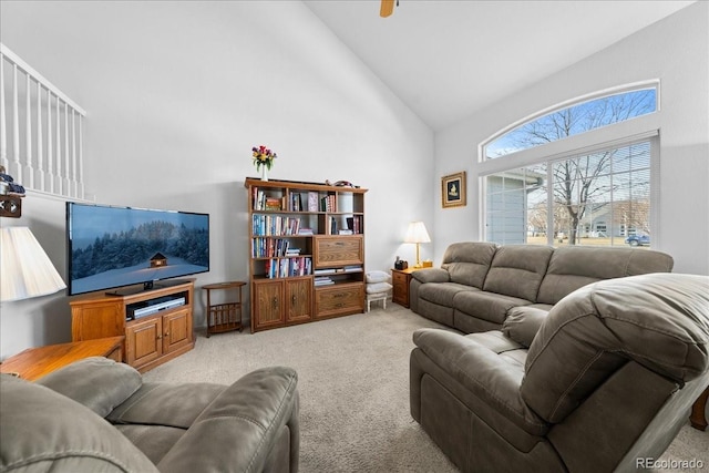 living area with light carpet and high vaulted ceiling