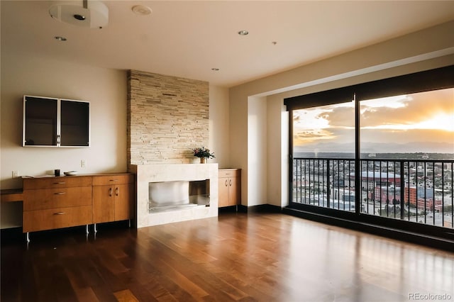 1133 14th St Unit 2110, Denver, CO 80202 - unfurnished living room featuring dark wood finished floors and a stone fireplace