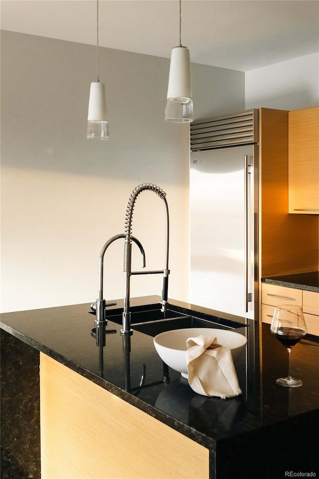 1133 14th St Unit 2110, Denver, CO 80202 - kitchen with built in refrigerator, pendant lighting, and dark stone counters