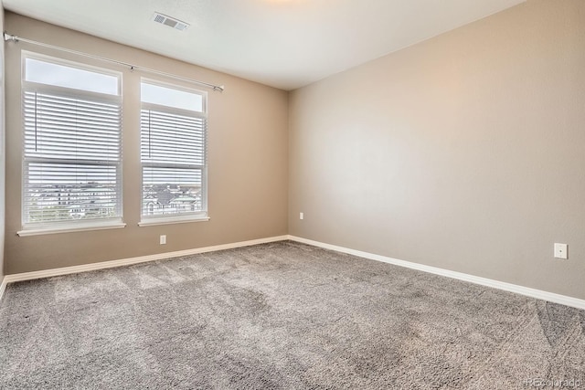 carpeted spare room featuring baseboards