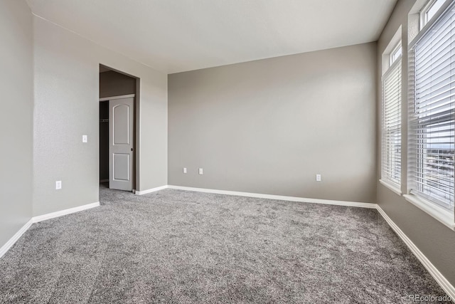 empty room featuring carpet flooring and baseboards