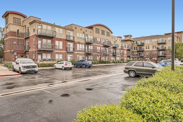 view of apartment building / complex featuring uncovered parking