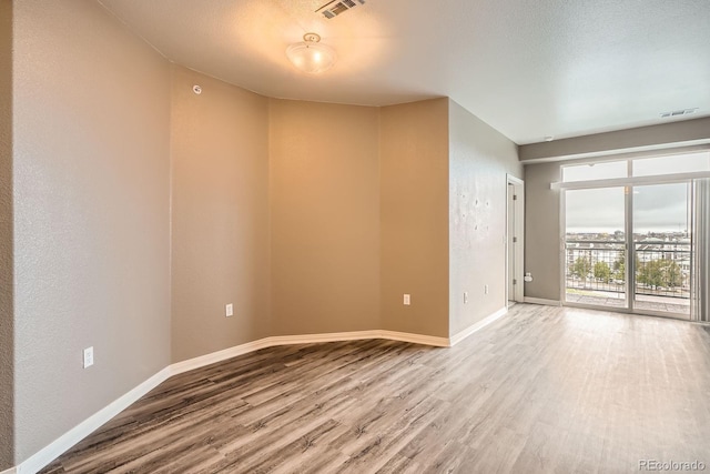 unfurnished room with wood finished floors and baseboards
