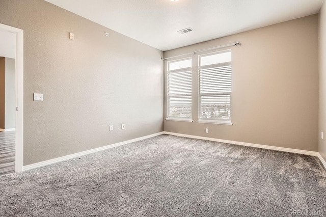 empty room featuring carpet floors and baseboards