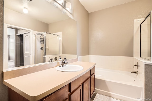 full bathroom with a garden tub, a stall shower, vanity, and a textured wall