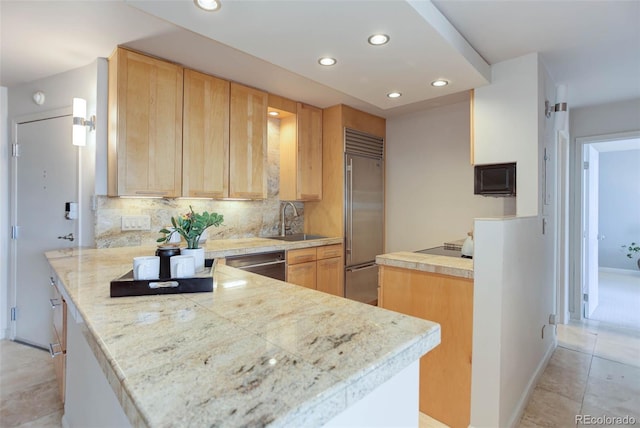 kitchen with sink, appliances with stainless steel finishes, decorative backsplash, kitchen peninsula, and light brown cabinets