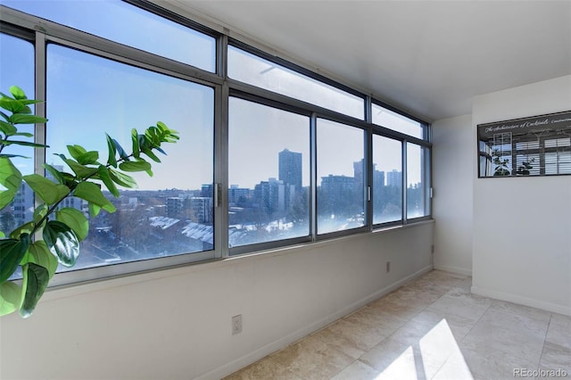 unfurnished room with a water view and light tile patterned floors