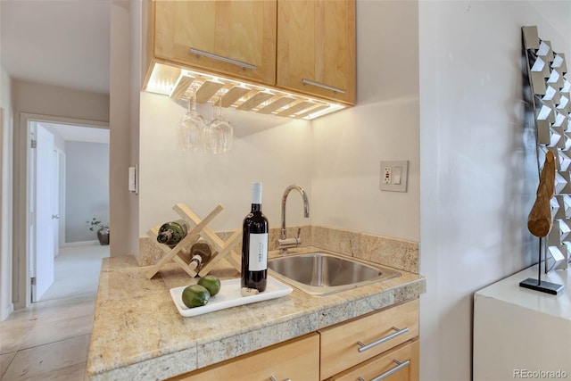 kitchen featuring light brown cabinetry, sink, and light carpet