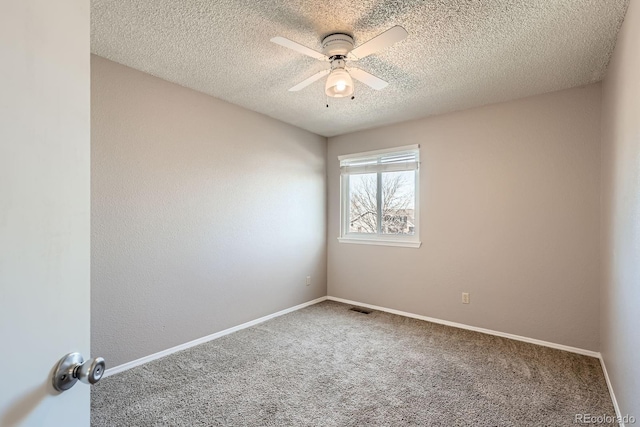 unfurnished room featuring visible vents, ceiling fan, baseboards, carpet, and a textured ceiling