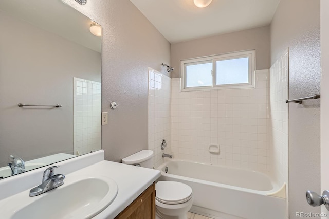 full bath with washtub / shower combination, toilet, vanity, and a textured wall