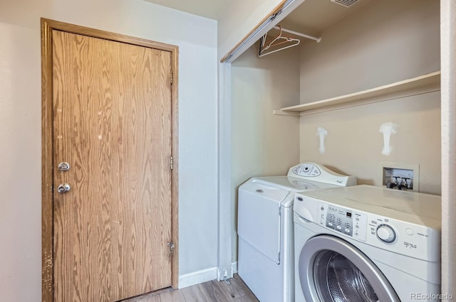 laundry area featuring visible vents, baseboards, laundry area, light wood-style floors, and washing machine and dryer