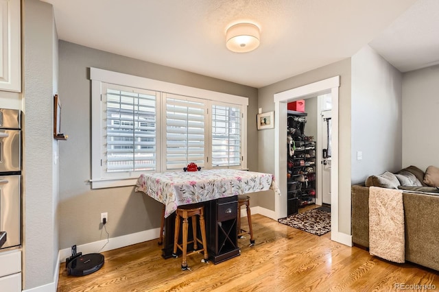 dining area with light wood-style floors and baseboards