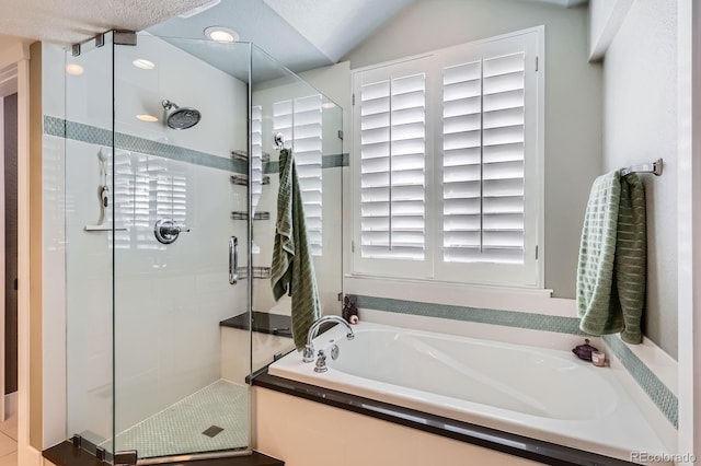 bathroom with a stall shower, lofted ceiling, and a garden tub