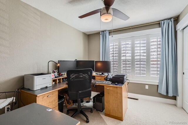 carpeted office with a textured ceiling, ceiling fan, and a textured wall