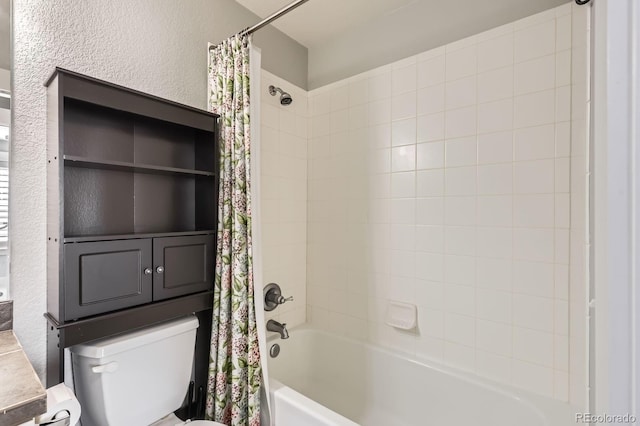 full bath featuring shower / bath combo with shower curtain, toilet, and a textured wall