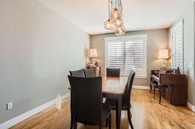 dining space featuring light wood finished floors and baseboards