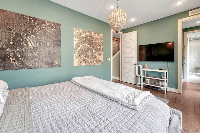 bedroom featuring visible vents, baseboards, recessed lighting, an inviting chandelier, and wood finished floors