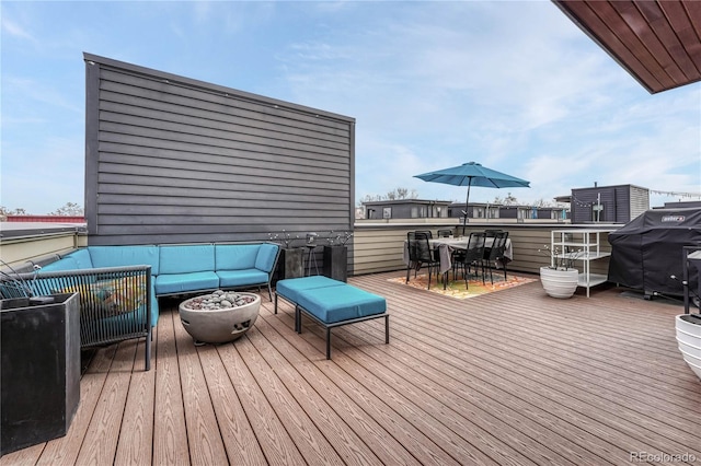 wooden deck featuring area for grilling, an outdoor living space with a fire pit, and outdoor dining area