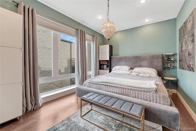 bedroom featuring a notable chandelier, recessed lighting, baseboards, and hardwood / wood-style flooring