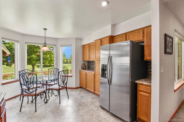 13235 Clermont Cir, Thornton, CO 80241 - kitchen with stainless steel fridge, decorative backsplash, and brown cabinets