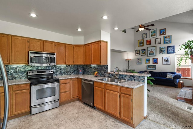 13235 Clermont Cir, Thornton, CO 80241 - kitchen featuring stainless steel appliances, open floor plan, a peninsula, ceiling fan, and brown cabinetry