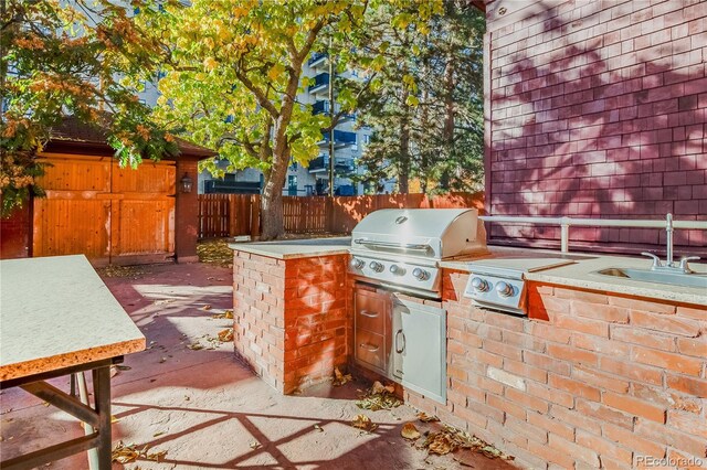 view of patio with a grill, exterior kitchen, and sink