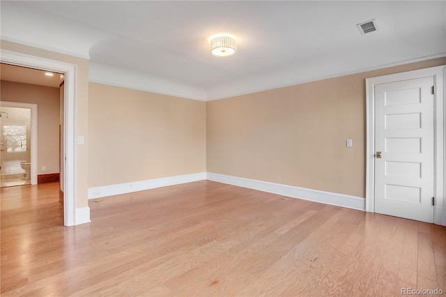 unfurnished room featuring light wood-type flooring and crown molding