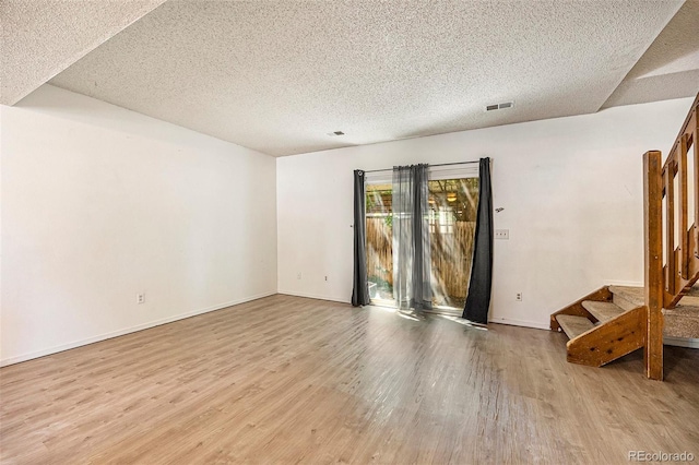 1545 S Ouray Cir Unit B, Aurora, CO 80017 - spare room with wood finished floors, a textured ceiling, and stairway
