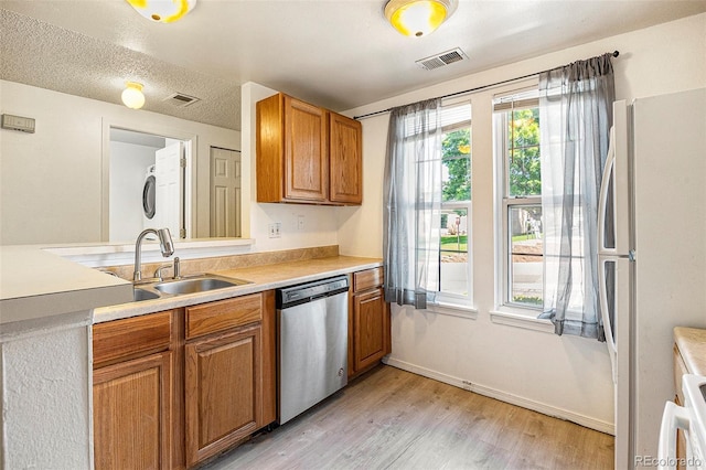 1545 S Ouray Cir Unit B, Aurora, CO 80017 - kitchen with dishwasher, freestanding refrigerator, light countertops, and brown cabinets