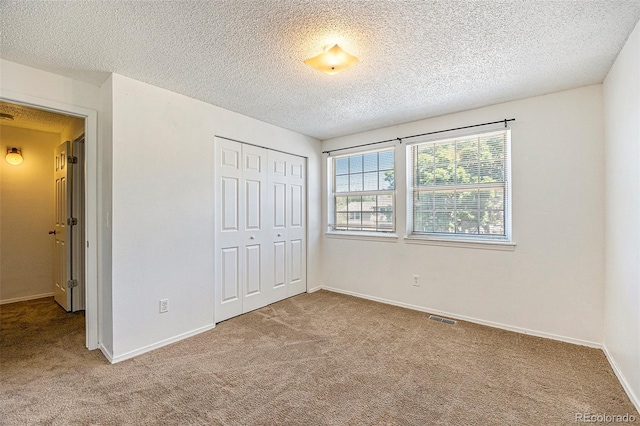 1545 S Ouray Cir Unit B, Aurora, CO 80017 - unfurnished bedroom with carpet flooring, a closet, and a textured ceiling
