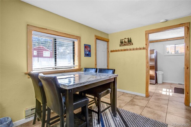 dining room featuring light tile patterned floors, baseboards, and baseboard heating