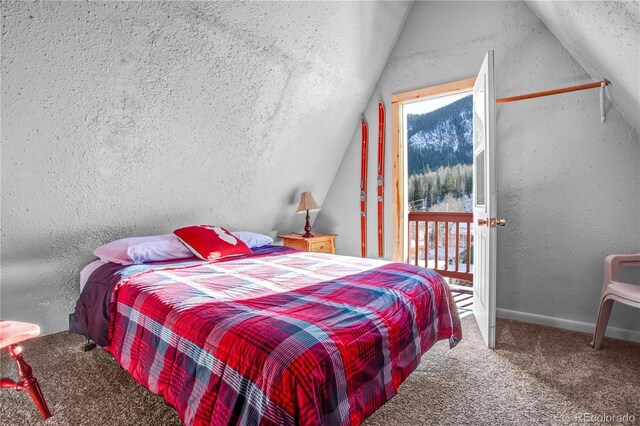 carpeted bedroom with access to exterior, lofted ceiling, multiple windows, and a textured wall