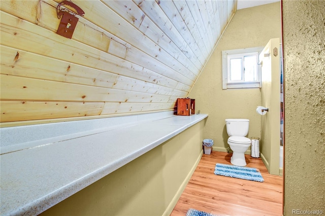 bathroom featuring lofted ceiling, toilet, wood finished floors, wood ceiling, and baseboards