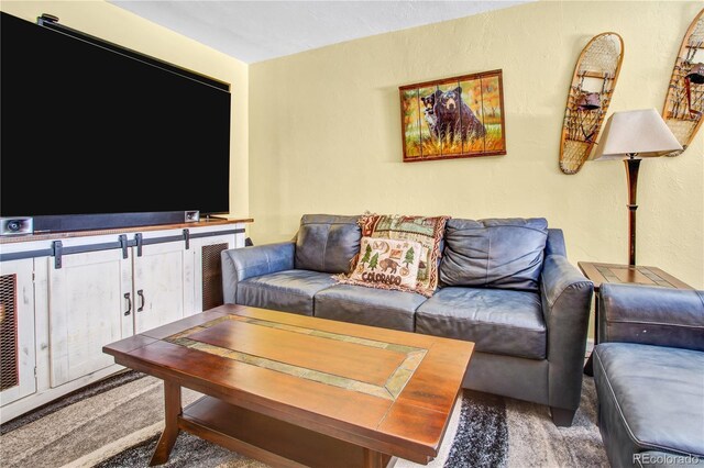 carpeted living room featuring a textured wall