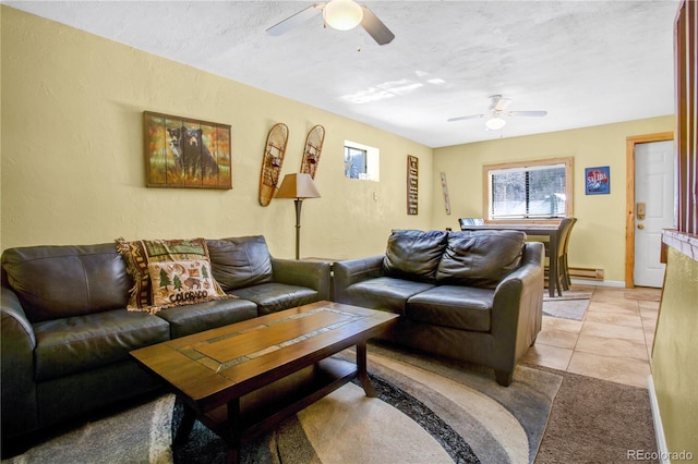 living room featuring a ceiling fan, a textured ceiling, baseboard heating, and light tile patterned floors