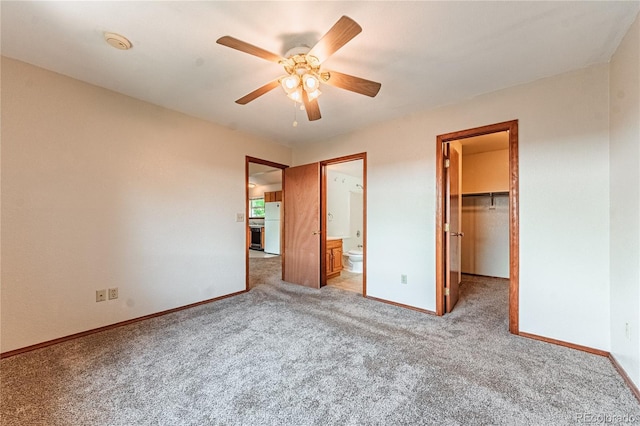 2408 N 7th St Unit A, Colorado Springs, CO 80907 - unfurnished bedroom featuring freestanding refrigerator, carpet flooring, a walk in closet, baseboards, and a ceiling fan