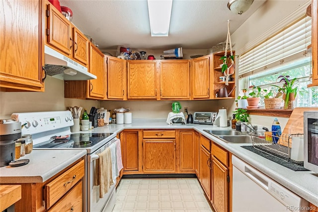 2408 N 7th St Unit A, Colorado Springs, CO 80907 - kitchen with white appliances, under cabinet range hood, light floors, a sink, and light countertops