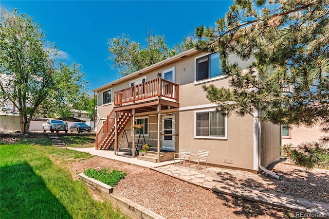 2408 N 7th St Unit A, Colorado Springs, CO 80907 - back of house featuring a lawn, a deck, stucco siding, and stairway