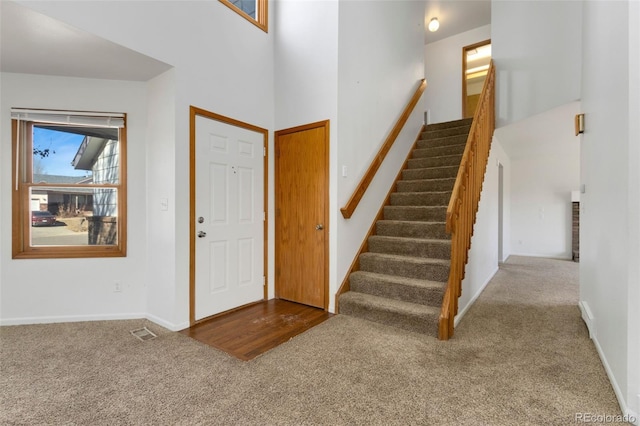 carpeted entrance foyer with a high ceiling