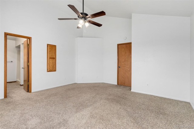 spare room featuring ceiling fan, high vaulted ceiling, and light carpet