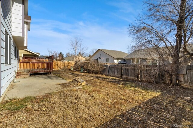 view of yard with a wooden deck and a patio