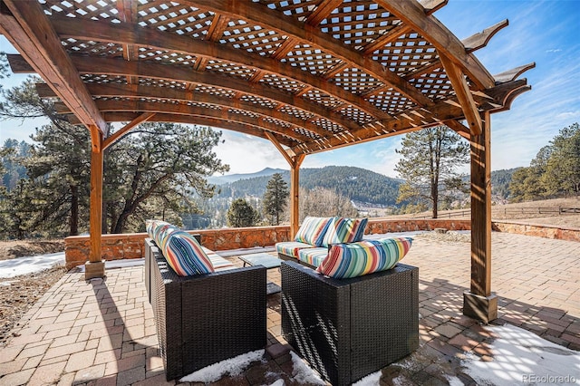 view of patio with an outdoor hangout area, a mountain view, and a pergola