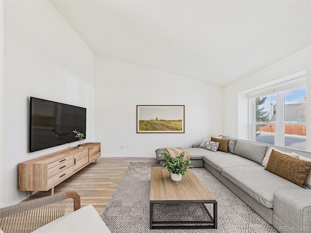 living area with lofted ceiling and light wood-style flooring