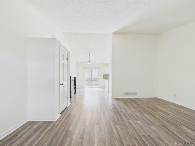 unfurnished room featuring visible vents, a textured ceiling, wood finished floors, baseboards, and ceiling fan