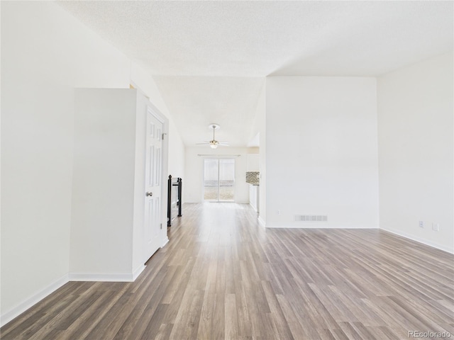 empty room featuring visible vents, baseboards, a textured ceiling, and wood finished floors