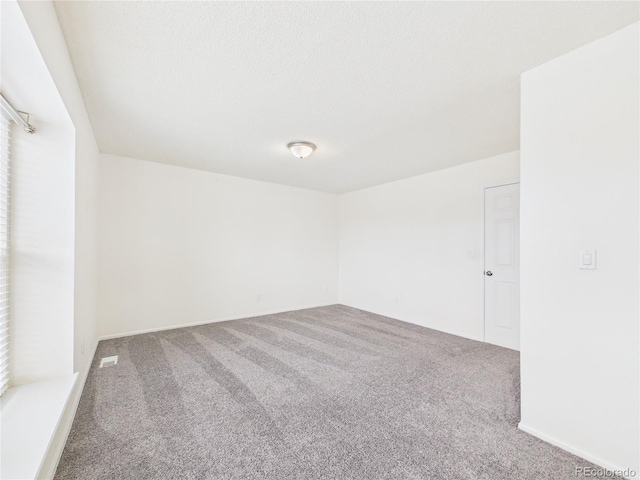 carpeted empty room featuring visible vents