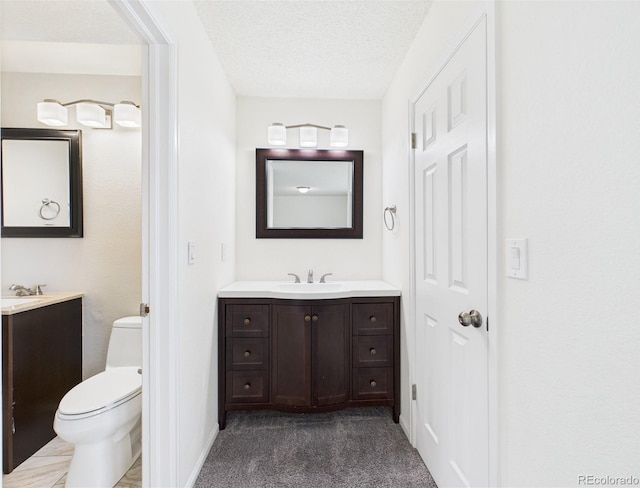 bathroom featuring vanity, toilet, and a textured ceiling